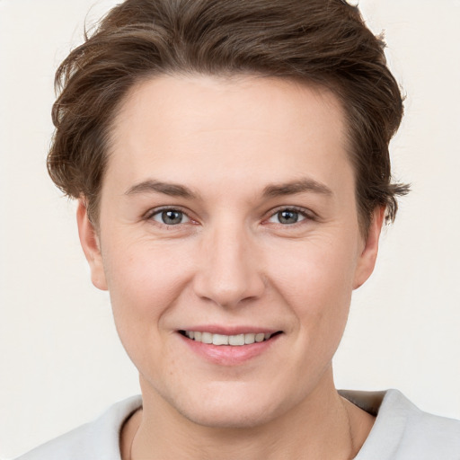 Joyful white young-adult female with short  brown hair and grey eyes