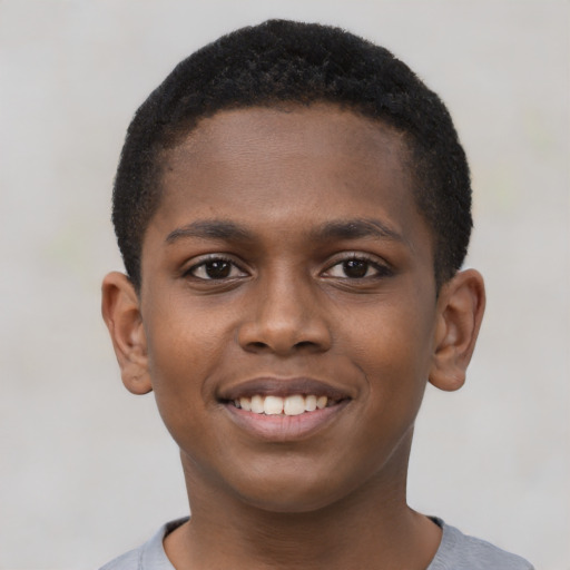 Joyful black child male with short  brown hair and brown eyes