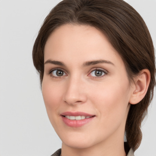 Joyful white young-adult female with medium  brown hair and grey eyes