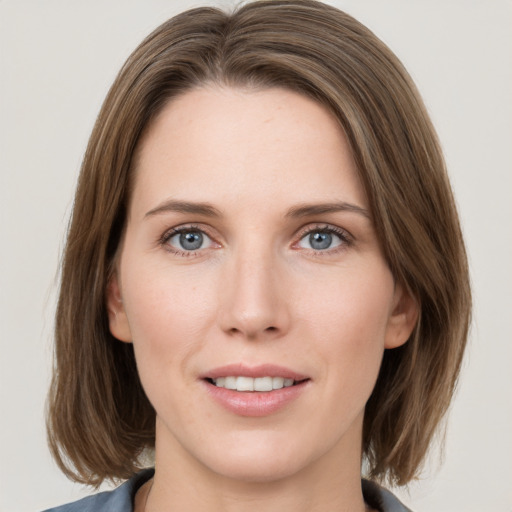 Joyful white young-adult female with medium  brown hair and grey eyes