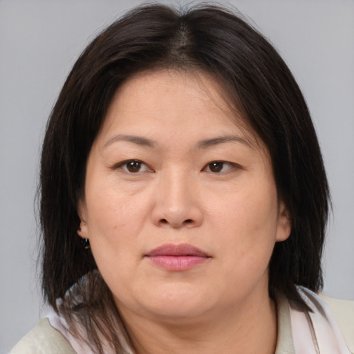 Joyful asian adult female with medium  brown hair and brown eyes