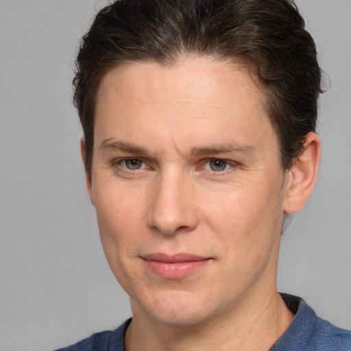 Joyful white adult male with short  brown hair and grey eyes