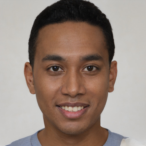 Joyful black young-adult male with short  black hair and brown eyes