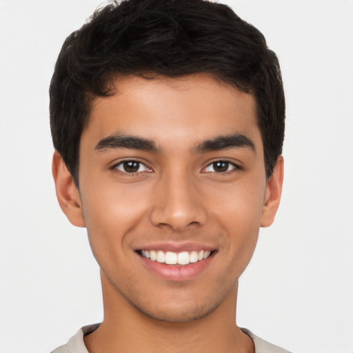 Joyful latino young-adult male with short  brown hair and brown eyes