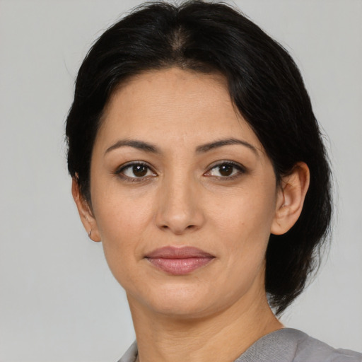 Joyful latino young-adult female with medium  black hair and brown eyes