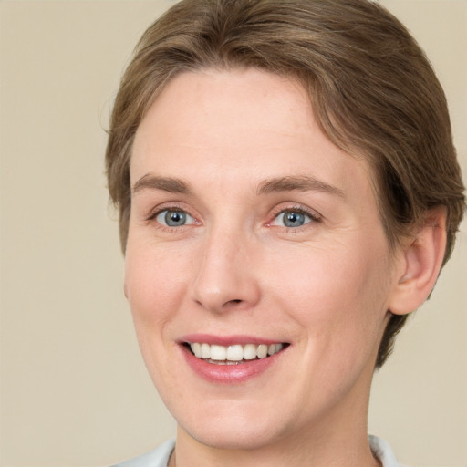 Joyful white young-adult female with short  brown hair and grey eyes