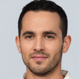 Joyful white young-adult male with short  black hair and brown eyes