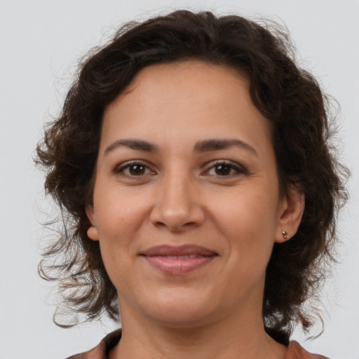 Joyful latino adult female with medium  brown hair and brown eyes