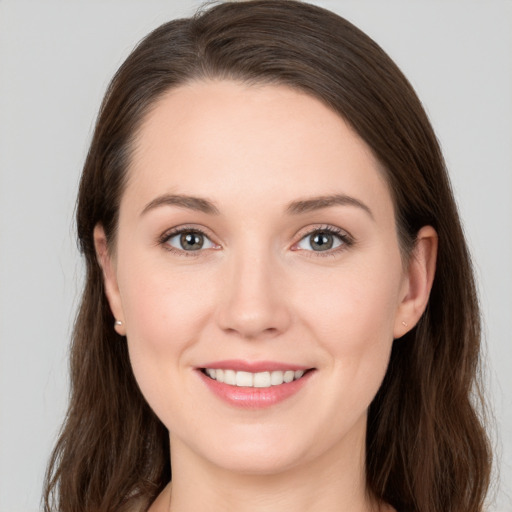 Joyful white young-adult female with long  brown hair and grey eyes