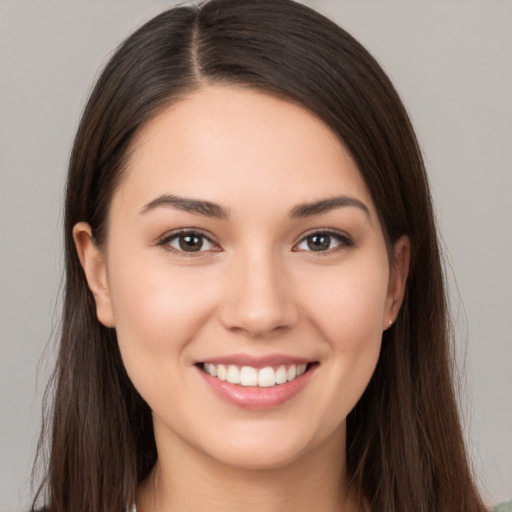 Joyful white young-adult female with long  brown hair and brown eyes