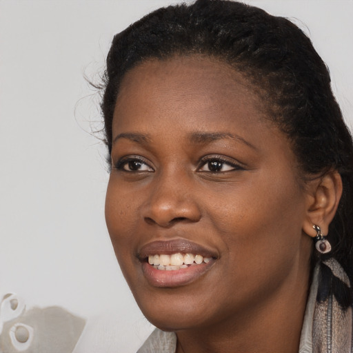 Joyful black young-adult female with long  black hair and brown eyes