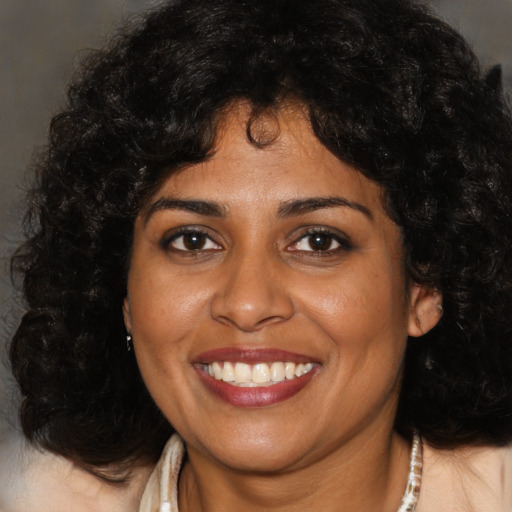 Joyful black adult female with medium  brown hair and brown eyes