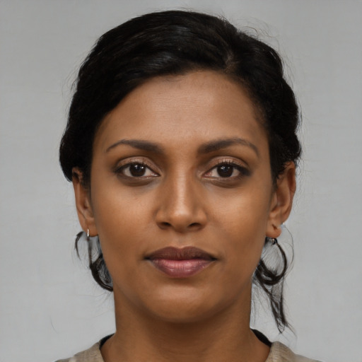 Joyful black young-adult female with medium  black hair and brown eyes