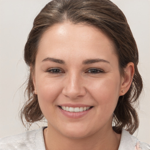 Joyful white young-adult female with medium  brown hair and grey eyes