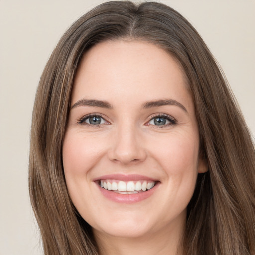 Joyful white young-adult female with long  brown hair and green eyes