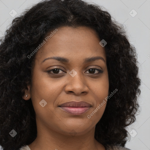 Joyful black young-adult female with long  brown hair and brown eyes