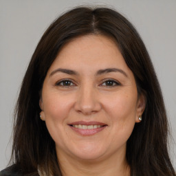 Joyful white adult female with long  brown hair and brown eyes