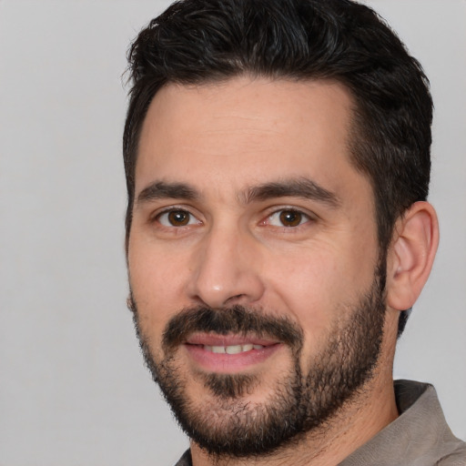 Joyful white adult male with short  black hair and brown eyes