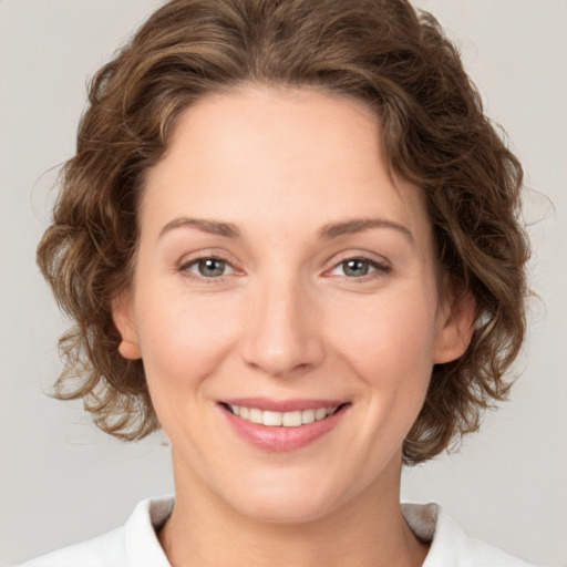 Joyful white young-adult female with medium  brown hair and green eyes