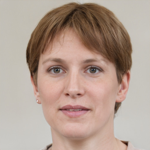 Joyful white young-adult female with short  brown hair and grey eyes