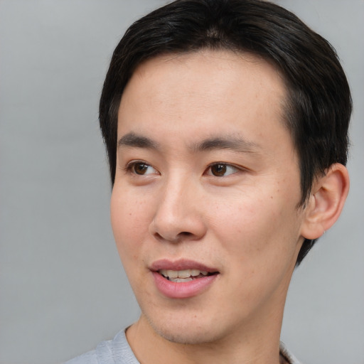 Joyful asian young-adult male with short  brown hair and brown eyes