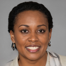 Joyful black young-adult female with short  black hair and brown eyes