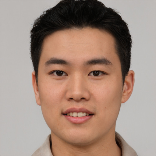Joyful asian young-adult male with short  black hair and brown eyes