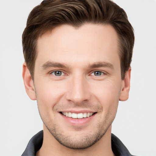 Joyful white young-adult male with short  brown hair and grey eyes