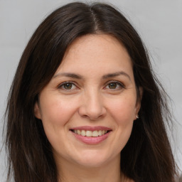 Joyful white adult female with long  brown hair and brown eyes