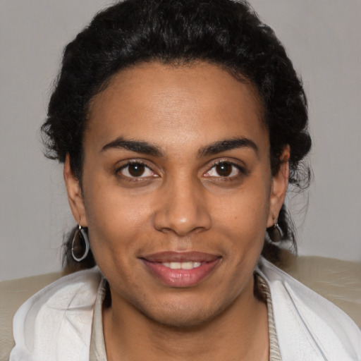 Joyful black young-adult female with short  brown hair and brown eyes