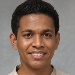 Joyful latino young-adult male with short  brown hair and brown eyes