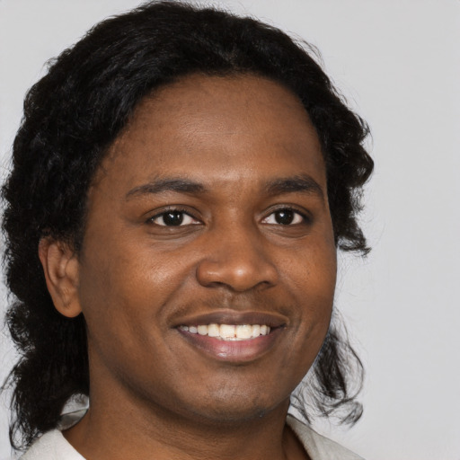 Joyful black young-adult male with medium  brown hair and brown eyes
