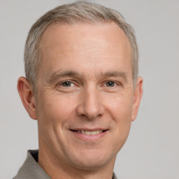 Joyful white adult male with short  brown hair and grey eyes