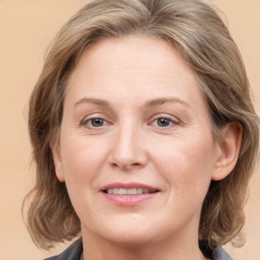 Joyful white adult female with medium  brown hair and grey eyes