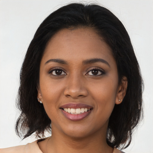 Joyful black young-adult female with long  brown hair and brown eyes