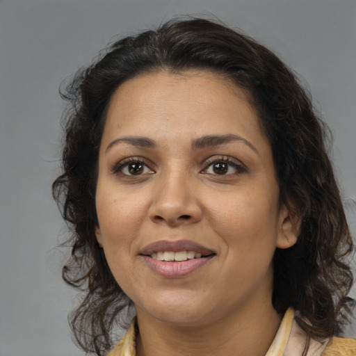 Joyful latino young-adult female with medium  brown hair and brown eyes