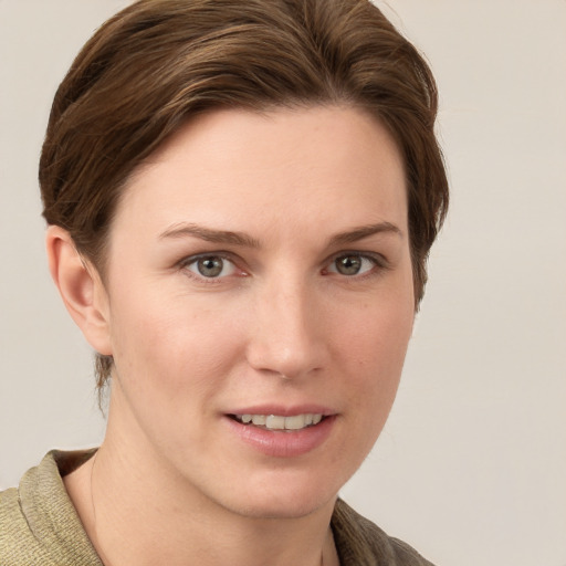 Joyful white young-adult female with short  brown hair and grey eyes