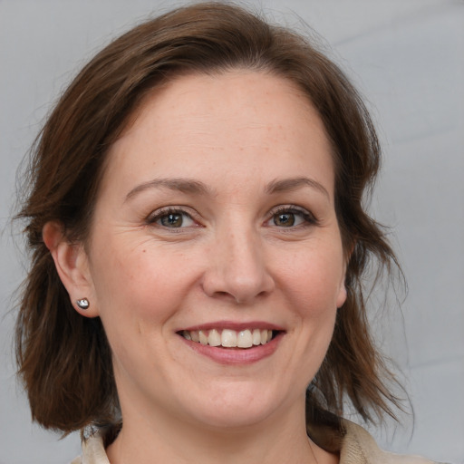 Joyful white adult female with medium  brown hair and blue eyes