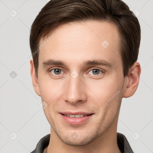 Joyful white young-adult male with short  brown hair and grey eyes