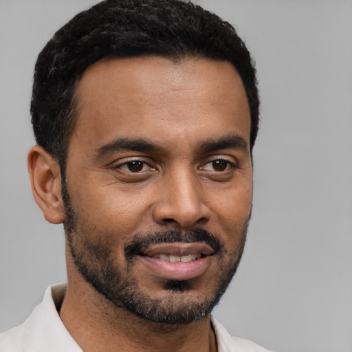 Joyful black young-adult male with short  black hair and brown eyes
