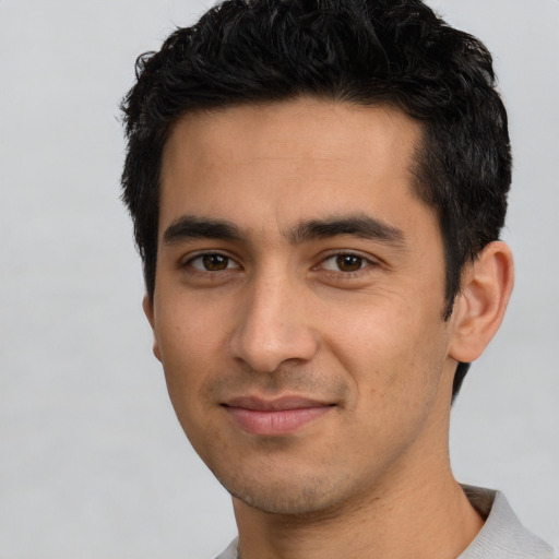 Joyful white young-adult male with short  black hair and brown eyes