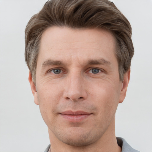 Joyful white adult male with short  brown hair and grey eyes