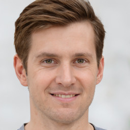 Joyful white adult male with short  brown hair and grey eyes