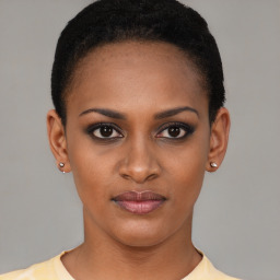 Joyful black young-adult female with short  black hair and brown eyes