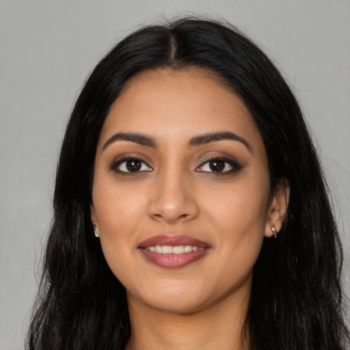 Joyful latino young-adult female with long  black hair and brown eyes