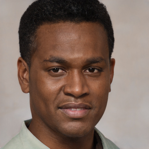 Joyful black young-adult male with short  brown hair and brown eyes