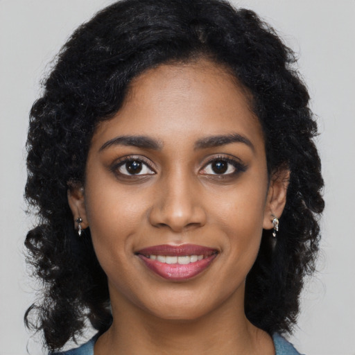 Joyful black young-adult female with long  black hair and brown eyes