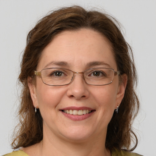 Joyful white adult female with medium  brown hair and green eyes