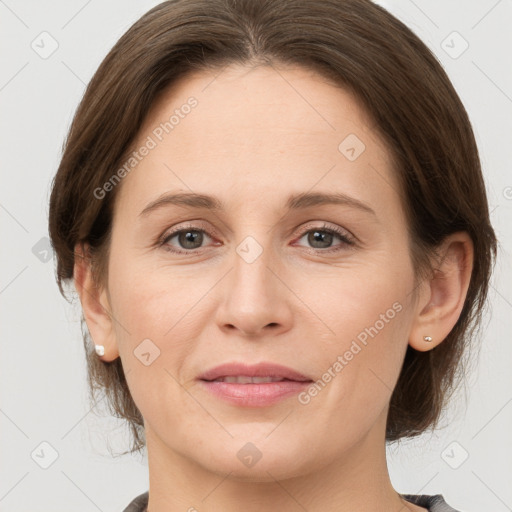 Joyful white adult female with medium  brown hair and grey eyes