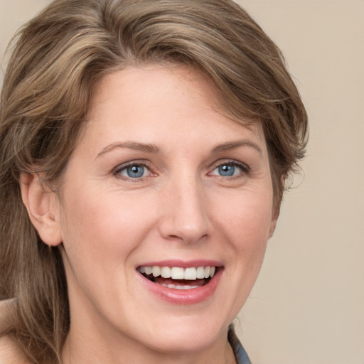 Joyful white young-adult female with medium  brown hair and blue eyes